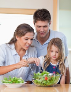 Portrait of a family preparing a salad in their kitchen